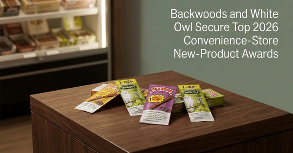Award-winning Backwoods Irish Cream and White Owl Red, White & Berry cigarillo packaging displayed on a wooden table.