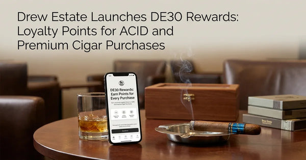 A smartphone showing a cigar loyalty app next to a premium ACID cigar and a humidor in a luxury lounge setting.