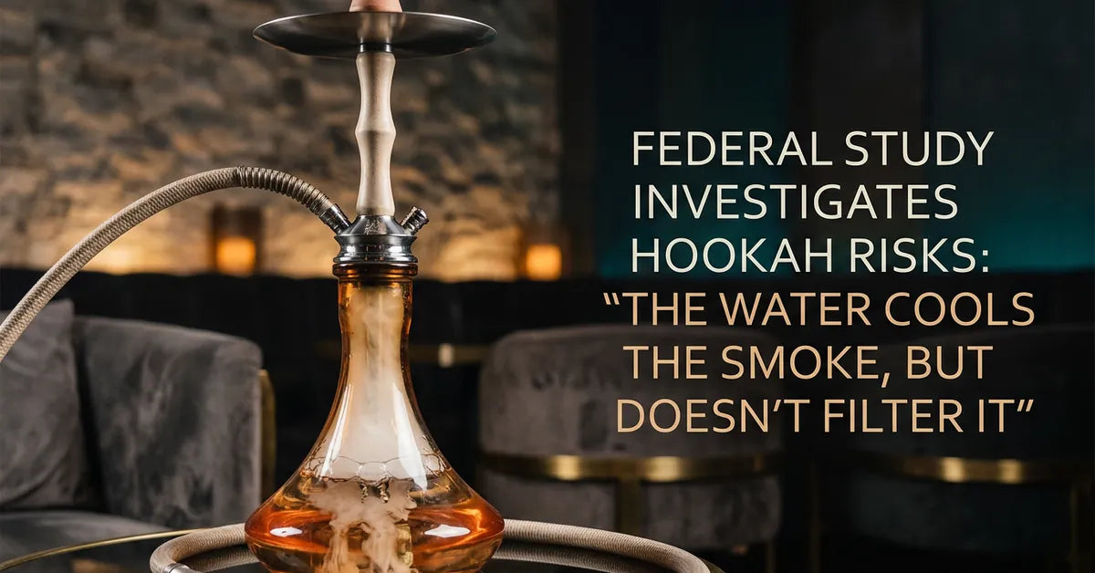 A close-up of a glass hookah base filled with white smoke in a dimly lit setting.