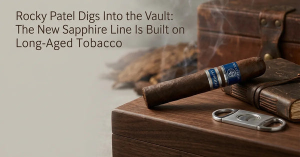 A Rocky Patel Sapphire cigar with a blue and silver band resting on a wooden surface.